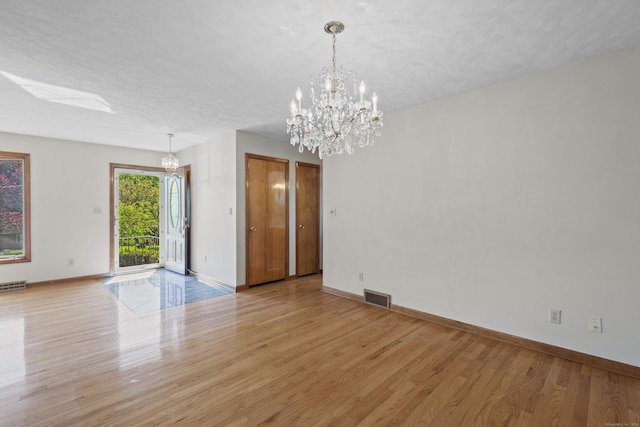 246 Sea Hill Rd, North Branford, CT 06471 - empty room featuring light wood-style floors, a chandelier, and baseboards