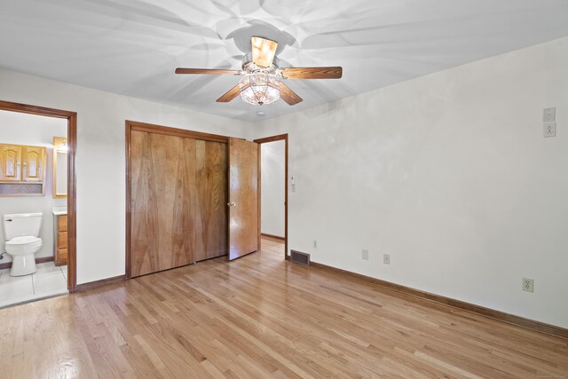 246 Sea Hill Rd, North Branford, CT 06471 - unfurnished bedroom with light wood-style floors, baseboards, connected bathroom, a ceiling fan, and a closet