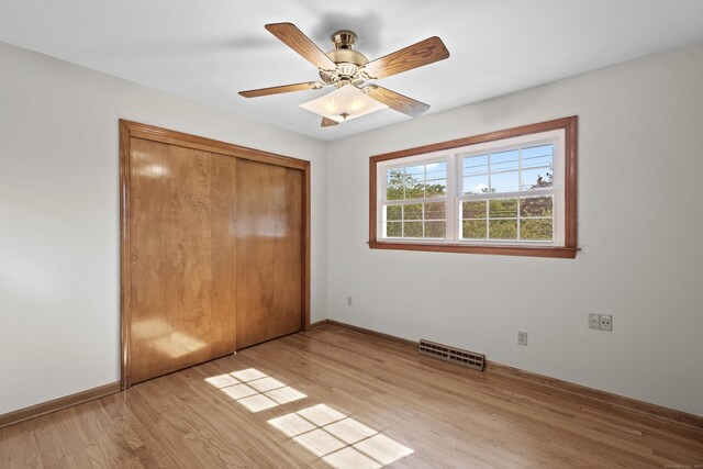 246 Sea Hill Rd, North Branford, CT 06471 - unfurnished bedroom featuring light wood-style flooring, baseboards, a closet, and a ceiling fan