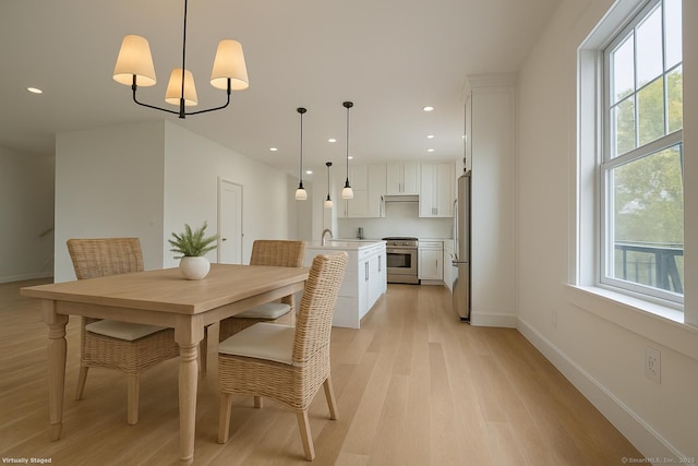 dining room featuring light wood-style flooring, baseboards, and recessed lighting