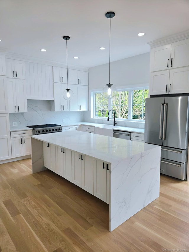 kitchen featuring appliances with stainless steel finishes, light wood-type flooring, decorative backsplash, white cabinetry, and recessed lighting