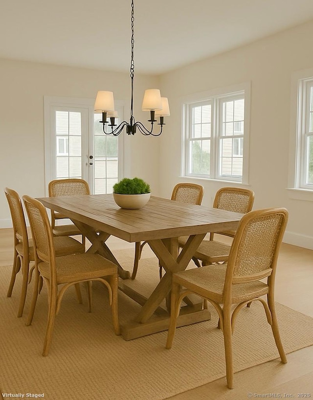 dining room featuring a chandelier and baseboards