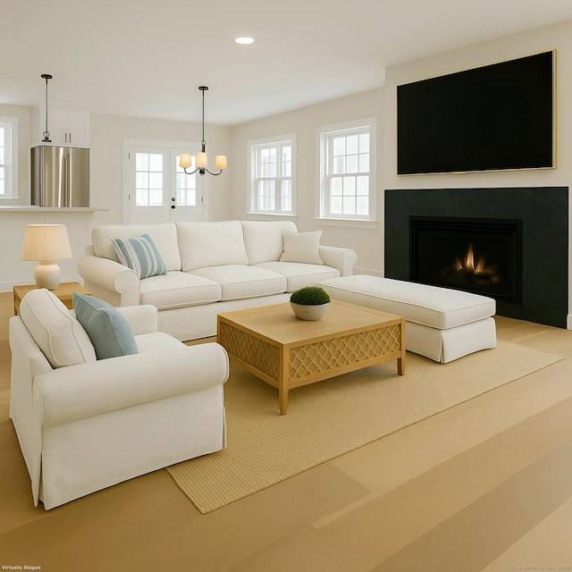 living area with a chandelier, recessed lighting, a lit fireplace, and wood finished floors