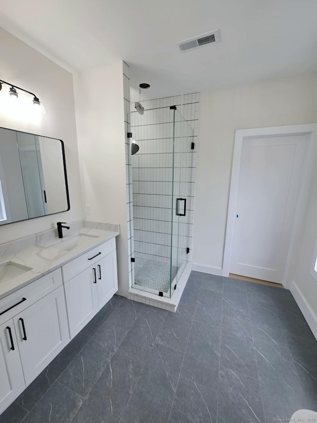bathroom with a stall shower, double vanity, and baseboards