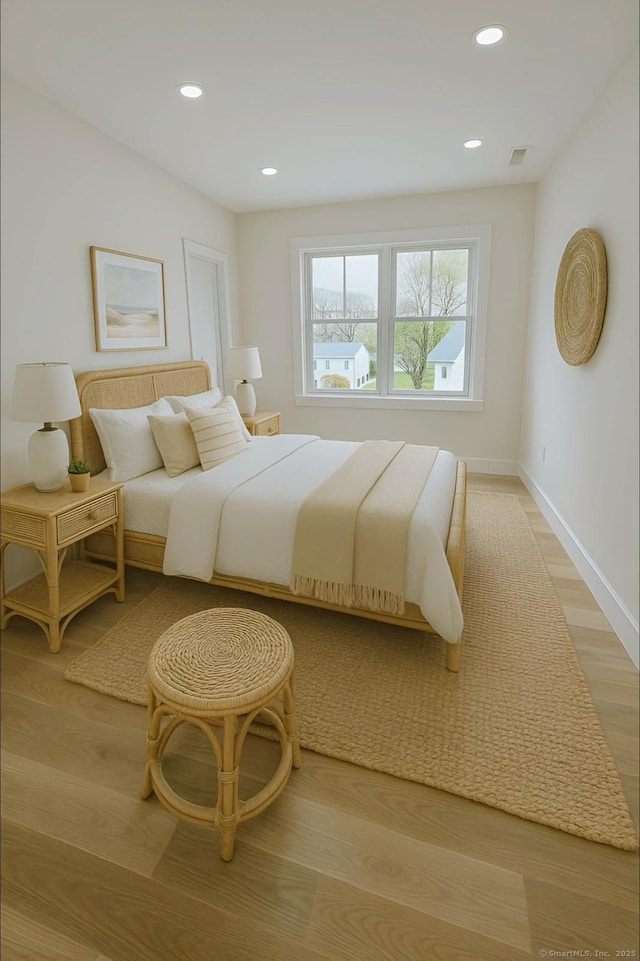 bedroom with baseboards, recessed lighting, and light wood finished floors