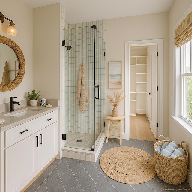 bathroom featuring a shower stall, vanity, and a spacious closet