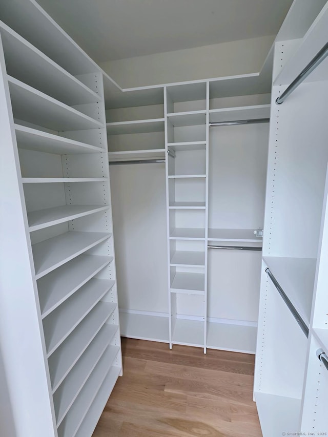 walk in closet with wood finished floors