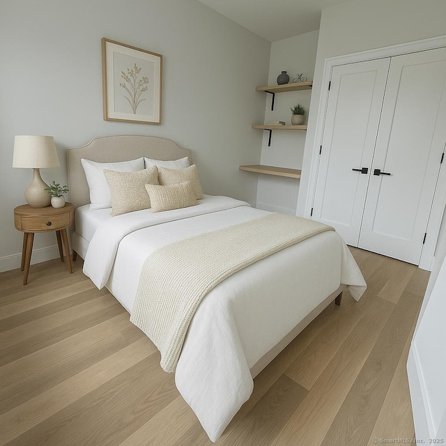 bedroom with light wood finished floors and a closet