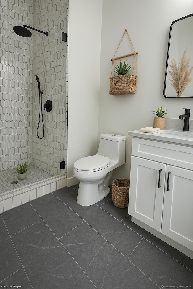 full bathroom with a tile shower, toilet, vanity, and tile patterned flooring