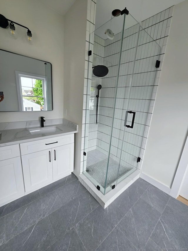 full bathroom featuring a shower stall, vanity, and baseboards