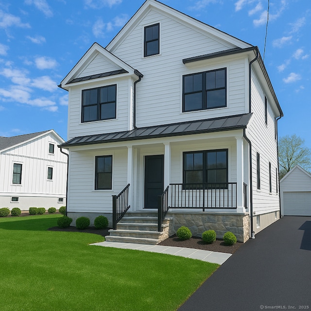modern inspired farmhouse featuring a standing seam roof, an outdoor structure, a porch, a garage, and a front yard