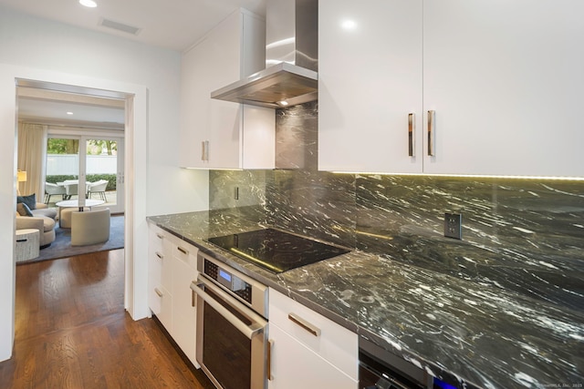 2 Mead St Unit 20, New Canaan, CT 06840 - kitchen with stainless steel oven, wall chimney exhaust hood, black electric cooktop, white cabinetry, and dark wood-style flooring