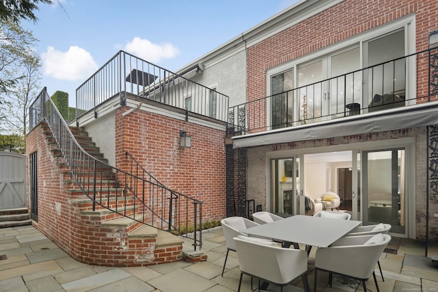 2 Mead St Unit 20, New Canaan, CT 06840 - view of patio featuring stairway, a balcony, and outdoor dining space