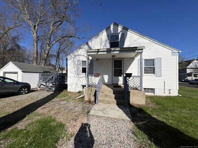 bungalow-style home featuring a front lawn and an outbuilding