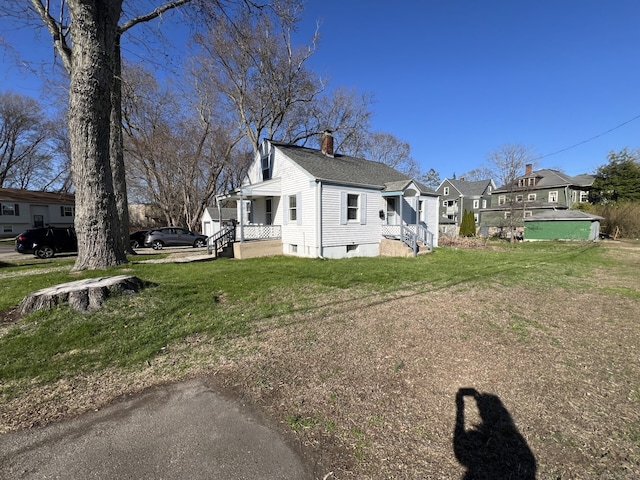 view of home's exterior with a yard, a chimney, and a residential view
