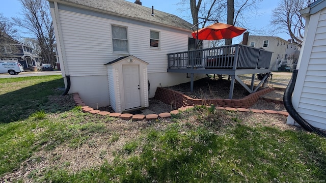 rear view of house featuring a lawn and a wooden deck
