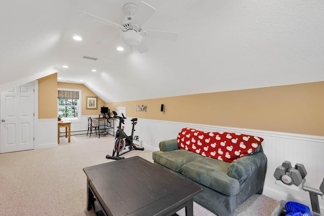 carpeted living area with visible vents, ceiling fan, recessed lighting, a wainscoted wall, and vaulted ceiling