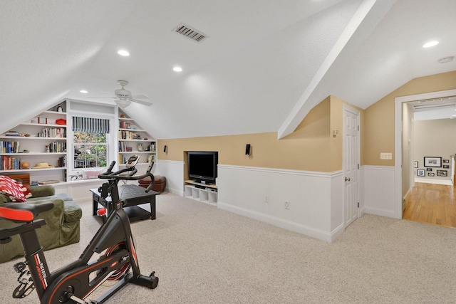 interior space with wainscoting, a ceiling fan, recessed lighting, vaulted ceiling, and visible vents