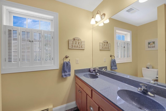 bathroom with visible vents, a sink, double vanity, and toilet