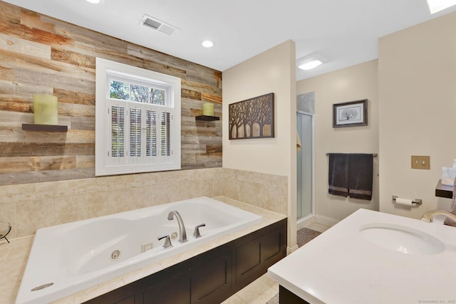 full bathroom with a sink, a whirlpool tub, recessed lighting, visible vents, and a stall shower