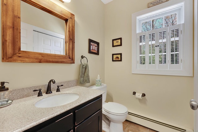 half bathroom featuring vanity, tile patterned flooring, baseboard heating, and toilet