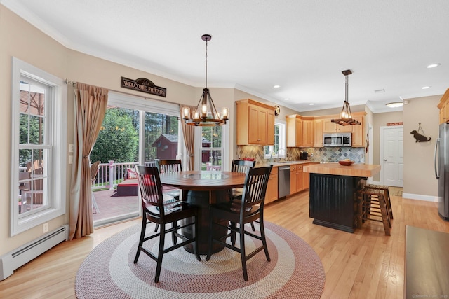 dining area with an inviting chandelier, ornamental molding, baseboard heating, and light wood-style flooring