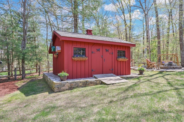 view of shed featuring an outdoor fire pit and fence