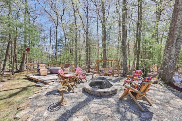 view of patio / terrace with a wooden deck and an outdoor fire pit