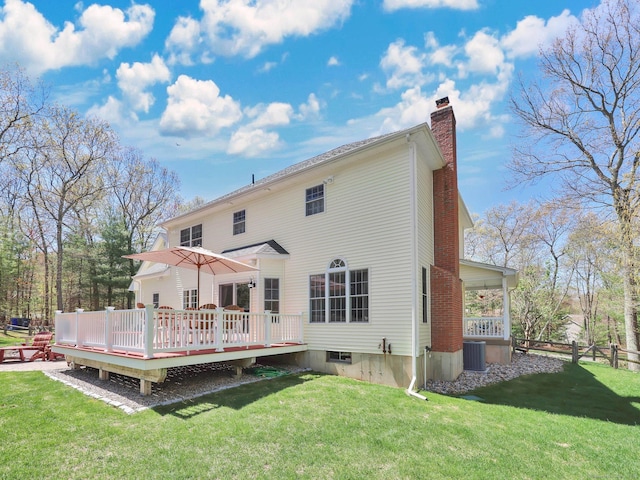 back of house with fence, a deck, a chimney, a lawn, and central air condition unit