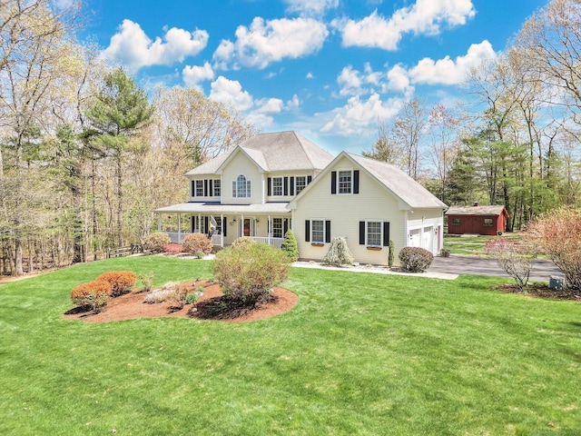 view of front of home with a porch, an attached garage, driveway, and a front lawn