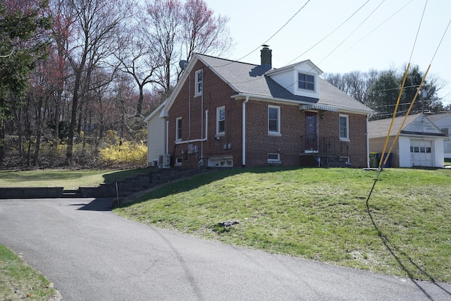 exterior space with brick siding, a yard, cooling unit, and a chimney