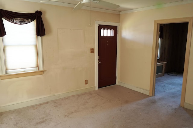 foyer entrance featuring baseboards, a ceiling fan, carpet flooring, and ornamental molding