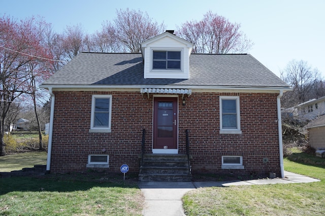 view of front of property with brick siding, entry steps, and a front yard