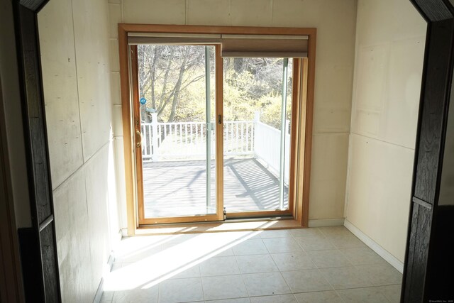 doorway featuring baseboards and light tile patterned flooring