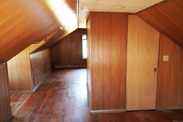 additional living space with lofted ceiling, wood walls, a baseboard heating unit, and dark wood-style flooring