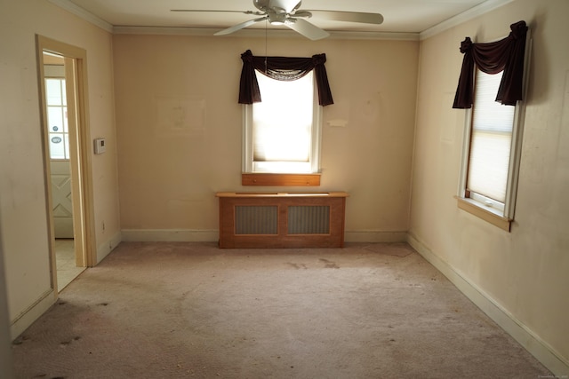 carpeted empty room with ceiling fan, baseboards, crown molding, and radiator