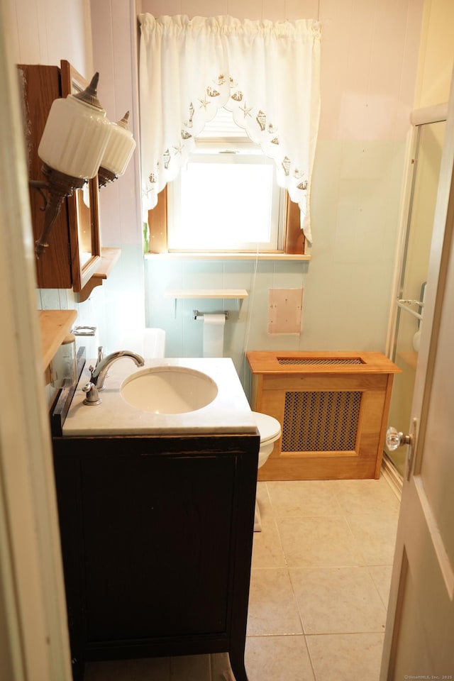 bathroom featuring tile patterned floors, toilet, radiator, a shower, and vanity