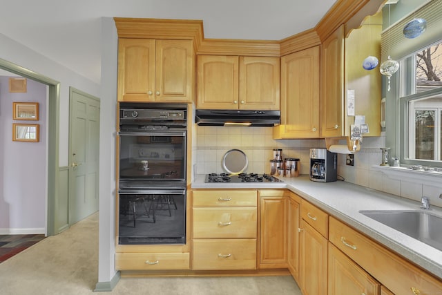 kitchen featuring decorative backsplash, light countertops, under cabinet range hood, a sink, and black appliances