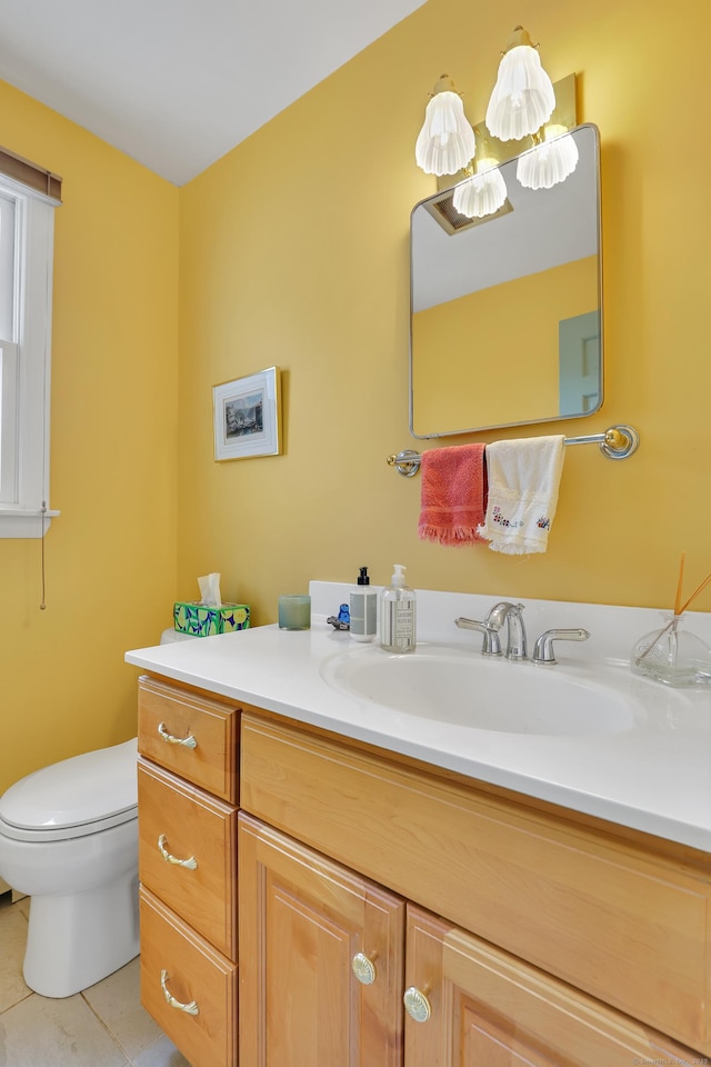 half bathroom with toilet, tile patterned flooring, and vanity