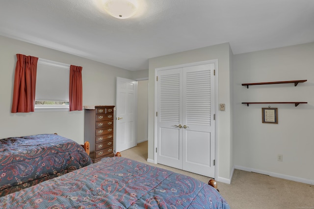 carpeted bedroom with baseboards and a closet