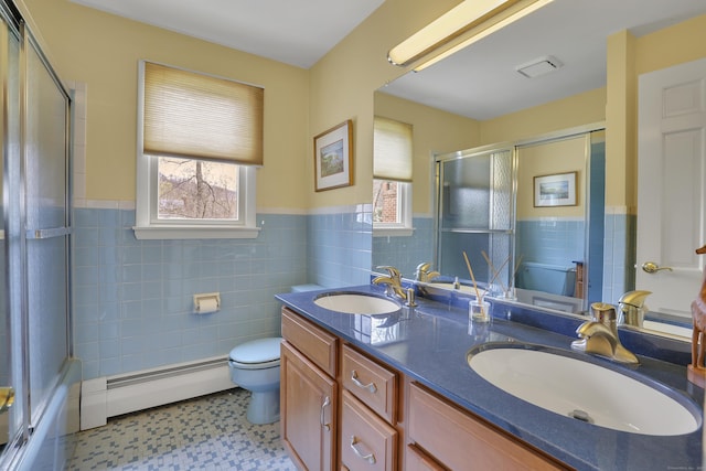 bathroom with a sink, baseboard heating, and toilet