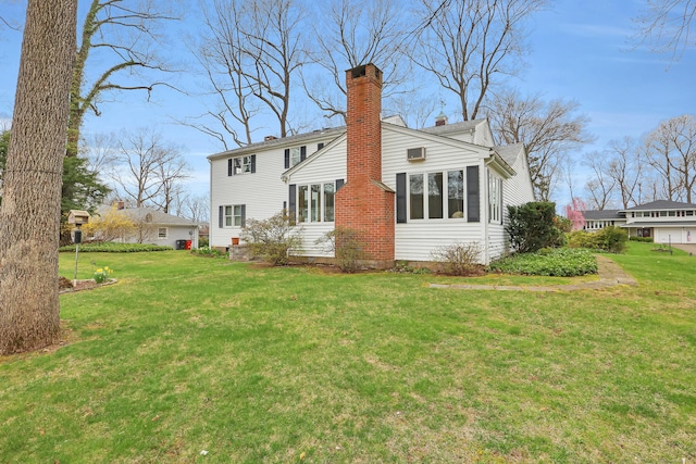 back of property with a chimney and a yard