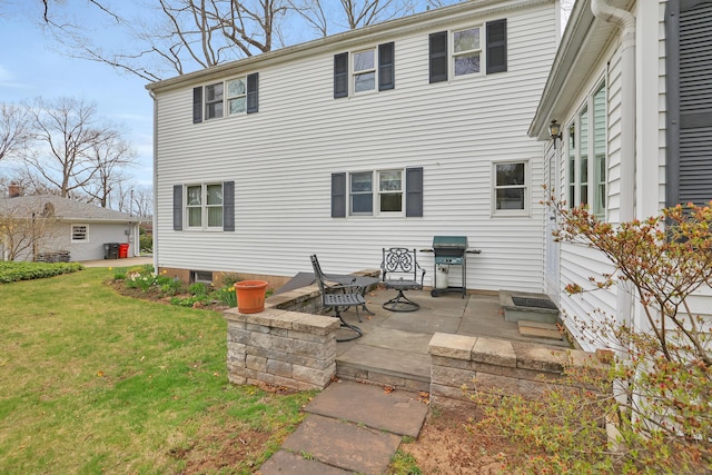 back of property with a lawn and a patio