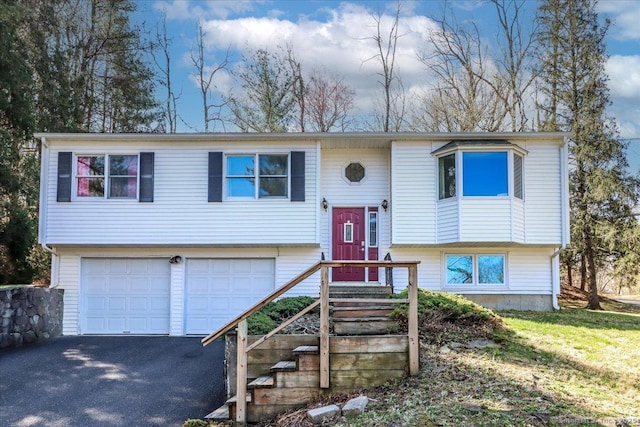 split foyer home with an attached garage and aphalt driveway