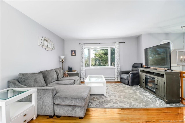 living area featuring baseboard heating and wood finished floors