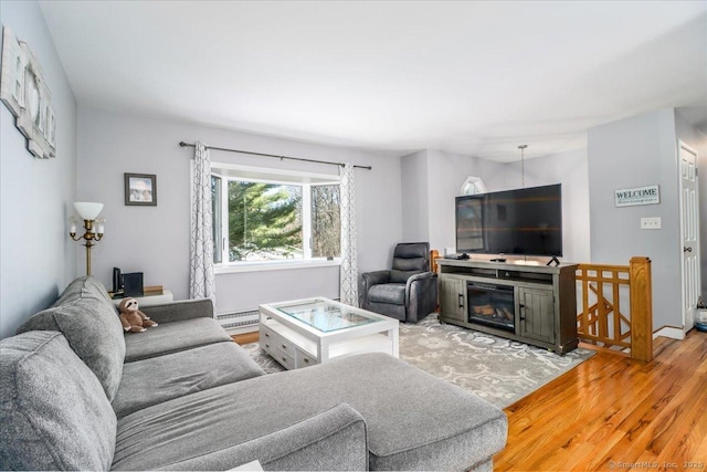 living room featuring a baseboard heating unit and light wood-style flooring