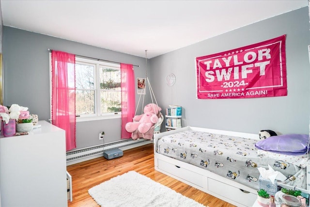 bedroom featuring a baseboard radiator and wood finished floors