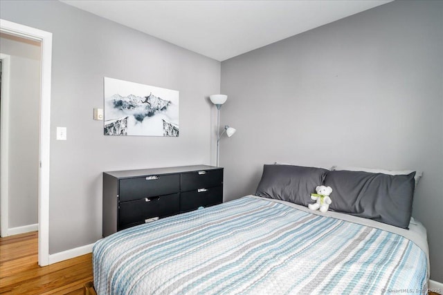 bedroom with wood finished floors and baseboards