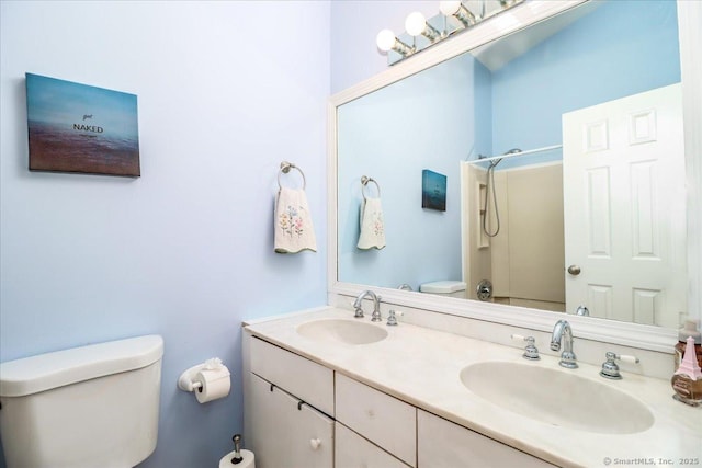 full bath with double vanity, walk in shower, toilet, and a sink