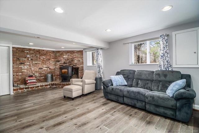 living area featuring recessed lighting, a wood stove, and light wood-type flooring